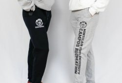 two students wearing black and gray joggers. the black joggers have a small campus recreation logo and underneath say montclair state university campus recreation. and the gray joggers have a small campus recreation logo and say montclair state university campus recreation going down the leg