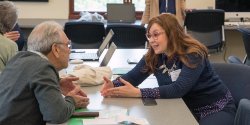 two faculty members talking across a table