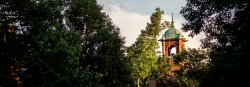 Scenic photo of Montclair State buildings peeking out from behind a treeline