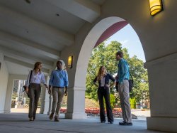 Students walking around near the amphitheater and Kasser Theater.