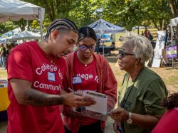 Two Kinesiology students going over test results with a festival attendee.