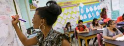 Teacher writing on board in classroom
