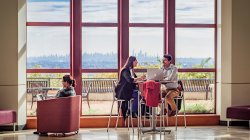 Two students sitting in the CELS building discussing things.