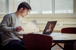 Student working at a computer seated at a desk