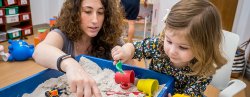 Specialist and child playing with sandbox