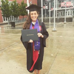 Graduate wearing cap and gown with bonner ribbon