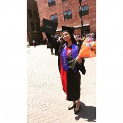 Graduate wearing cap and gown with bonner ribbon