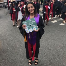 Graduate wearing cap and gown with bonner ribbon