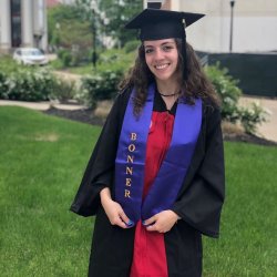 Graduate in cap and gown with bonner ribbon