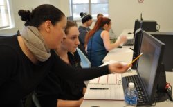 Professor pointing at someting on student's computer screen