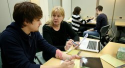 Janet Dengel (center), a consultant at the Center for Writing Excellence assists a student at the Center's new Sprague Library location.