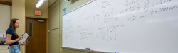 student takes notes from whiteboard