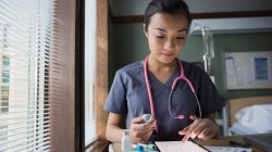 nurse in hospital room working on tablet