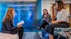 Students reading class materials in School of Communication and Media lounge