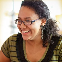 Young woman with with brown hair and glasses smiling