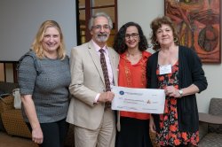 photo of event attendees holding a large donation check