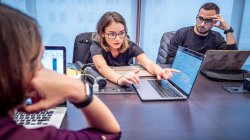 student and faculty discussion while looking at laptop