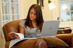 student studying at home with laptop and notebook