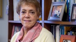 photo of Professor Deborah Fish Ragin in front of shelves with books and picture frames