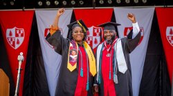 Father and daughter graduates, Lavone and Tiiera Broxton on stage at Commencement in their regalia