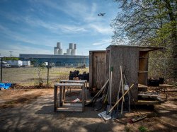A plane flies over the Ironbound section of Newark, New Jersey, where industrial facilities dominate the landscape. Down Bottom Farms, a community garden built on raised beds sits on top of an industrial brownfield and offers a hopeful vision of a healthy future.