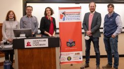 CHSS faculty members stand with organizer of festival