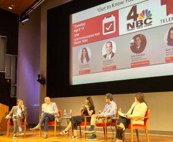 A group of five executives seated on a stage holding microphones as part of a panel discussion about job searches.