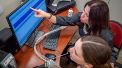 Elaine Hitchcock with student reviewing results on computer monitor