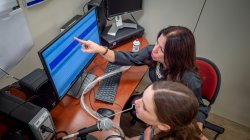 Elaine Hitchcock with student reviewing results on computer monitor