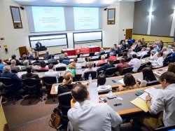 A broad view of a lecture hall from the back showcasing some of the whiteboards and projection equipment available.