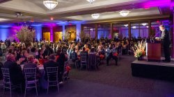 2014 Foundation Annual Scholarship Dinner. Tables and chairs set up at a night time eent with multi-colored lighting all around. One of the many setups available for the Conference Center's Main Ballroom.