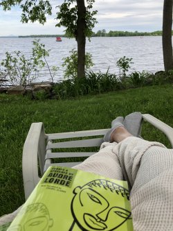 View from lawn chair holding book Essays and Speeches by Audre Lorde