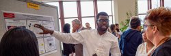 Uchenna Ezichi discussing research with Casabona Judge during the poster session