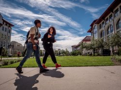 Two students walking on campus near Center of Environmental and Life Sciences