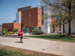 A student walking by one of the buildings on campus.
