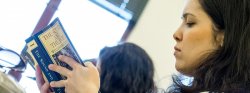 Image of a student reading a book in class.