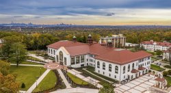 aerial photo of college hall with NYC skyline in the background at dusk