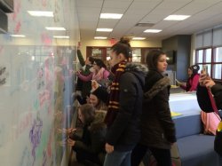 students signing whiteboard