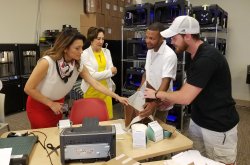 Two women look at innovation items made by two male students