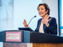 Mimi Feliciano at podium addressing attendees