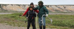 students in field posing with equipment