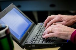 Hands typing on a laptop