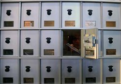 Close-up of letter being inserted into mailboxes.