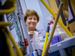 Housekeeper looking over housekeeping cart of products