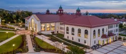 Aerial shot of College Hall exterior at dusk with lights on
