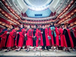 Master's Degree graduates in red caps and gowns