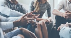 Hands of people in group therapy session