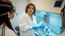 Meiyin Wu in lab speaking with students.