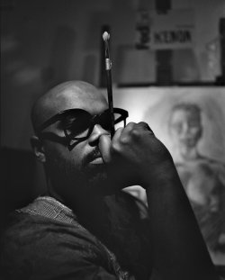 Portrait of artist Ajamu Kojo holding paintbrush