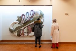 Two visitors look at the work in the cases at the Kasser Theater lobby.